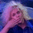 Pixelated image of a person with light-colored hair against a blue and purple gradient background, rendered in low-resolution style.