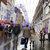 Pixelated static image showing multiple indistinct figures in a crowded scene with muted colors and no visible text.