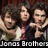 Three people with dark hair pose closely together, one holding a guitar-like instrument; text at bottom reads 'Joros Brothers' in white block letters.