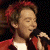 Clay Aiken performing on stage with microphone, red jacket, and white shirt in a 2x2 contact sheet layout showing multiple frames of the same image.