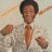 A pixelated image of a person in a light-colored patterned suit with an orange tie, showing text changes across frames.