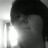 Pixelated grayscale image of a person's face with dark hair, partially obscured by light and shadow gradients.