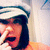 A pixelated image shows a person with dark hair wearing a white and blue striped headband, covering their face with one hand while text reads "boetcha cant do this!" in bold black letters.