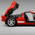 Red sports car with open rear hatch, black wheels, and white stripe on side against gray background.