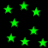 Green star shapes glow against a black background, scattered across the frame with varying sizes and positions.