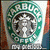 Starbucks logo with green circular text and siren, coffee cups on beige background, pixelated style.