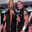 Two men holding microphones in a performance setting, one with long hair and dark clothing, the other with short hair and sleeveless top; two versions of this scene appear side-by-side.