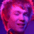 Pixelated image of a person with short light brown hair and closed eyes, next to green text on dark background.