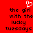 Red background with black pixelated text reading 'the girl with the lucky tuesdays' and a white heart outline above the text.