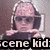 Pixelated image of a person with short dark hair wearing sunglasses and a light-colored cap, resting their chin on hands in front of a computer monitor.
