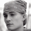 Three grayscale portrait show a person with changing hairstyles and headwear
