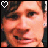 A 48x48 pixel animated contact sheet showing two sequential frames of a person's face with subtle expression changes, each frame featuring a white heart icon in the top-left corner against a dark background.