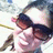 A person wearing dark sunglasses and a light-colored top appears in a with text overlays in bright pink