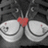 A static pixelated image shows two white spiral-shaped objects with a red heart between them on a dark gray background.