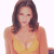 Pixelated image of a person with long brown hair wearing a yellow sleeveless top against white background.