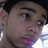 Static pixelated image of a person's face with visible eyes, nose, mouth, and ear, showing partial facial features against a dark background.