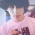 A person with dark curly hair wears a light pink shirt with brown text, shown in four where the head position shifts slightly left to right