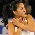 A pixelated static image shows a person with light skin and dark hair holding another figure in an embrace against a blurred background.