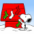 Pixelated Snoopy stands beside a red doghouse with green and white stockings, under blue sky with snow on ground; text 'Merry Christmas' appears in multiple color variations across the image.