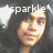 Pixelated image of a smiling person with dark hair, overlaid text reading 'sparkle' in white block letters and two star symbols on a gray background.