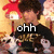 A pixelated image of a person with dark hair wearing a black shirt with gold text, holding a white dog-like figure, with text overlays changing across frames.
