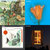 A static image divided into four quadrants showing pixelated scenes with greenery, blue sky, a white square with red dot, and orange shapes on dark background.
