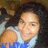 A person with long dark hair wearing a light blue sleeveless top, with blue text overlaid at the bottom of the image.