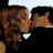 Two pixelated figures in close proximity, one with brown hair and the other with dark hair, against a black background.