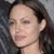 Pixelated close-up of a person's face with closed eyes, dark hair, and light skin tone against a blurred background.