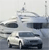 A pixelated static image shows a white vehicle with dark windows and a dark lower body section, positioned on a reflective surface with a light gray background.