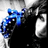 Blue and black pixelated figure with a large head, wide eyes, and an open mouth against a grayscale background.