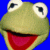 Pixelated green frog head with wide eyes and open mouth showing red tongue against solid blue background.