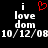 Black background with white pixelated text 'i love dom' and date '10/12/08', red heart symbol above 'i' on left side, identical text and date on right side.