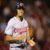 A pixelated image split into two : left shows a baseball player in white uniform with red text, right displays a large red sock logo on white background