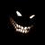 Pixelated static image of a dark, curved shape with two white oval eyes and a wide, toothy grin against black background.