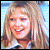 A pixelated image of a smiling person with long hair in three color variations: blue-toned, purple-toned, and pink-toned.