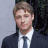 A 48x48 pixel buddy icon split into two vertical sections: a person in formal attire on the left and green text logo on the right, with visible pixelation and dithering effects.