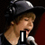 A four- shows a person in a black cap and dark shirt singing into a microphone with red background, displaying text overlays changing from 'I' to '<3'