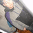 Pixelated static image shows a figure in motion with blurred limbs, light-colored top, dark lower body, and purple-blue accents on the side.