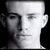Pixelated grayscale portrait of a person with short hair, neutral expression, and visible ears against black background.