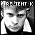 Black-and-white pixelated icon featuring a person's face with text "RELIENT K" in blocky white letters on black background at top, high-contrast grayscale rendering with visible dithering and aliasing artifacts.