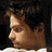A person with dark curly hair in a white shirt appears across four showing subtle facial expression changes