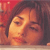 A pixelated close-up of a person's face with closed eyes, dark hair, and warm orange-brown tones against a red background.