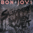 Pixelated image with blue and gray sections containing text fragments and a partial band name at top left.