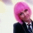 A person with bright pink hair and dark suit stands against a light background, with the word 'LIES' repeated below in gray text.