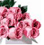 A static pixelated image of pink roses with green leaves, rendered in a low-resolution style typical of early 2000s digital art, set against a plain white background.