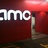 Pixelated image showing partial white text 'amc' on a dark red background with a lighter red gradient top section.