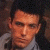 A pixelated image of a person with dark hair and light skin wearing a gray shirt, next to green text reading 'Original Icons .com' on a solid background.