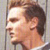 Static pixelated image of a person's head and shoulders in profile view with brown hair, light skin tone, and visible facial features including eye, nose, mouth, ear, and neck against a neutral background.