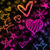 Pixelated static image featuring multiple heart shapes and star-like forms in pink, purple, orange, and yellow hues against a dark background.